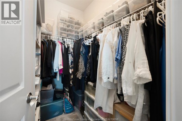 Walk-in closet with organized shelves and hanging clothes - 1225 Riverside Unit# 409 Windsor