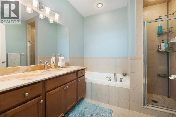 Bathroom with double vanity, soaking tub, and glass shower - 1225 Riverside Unit# 409 Windsor