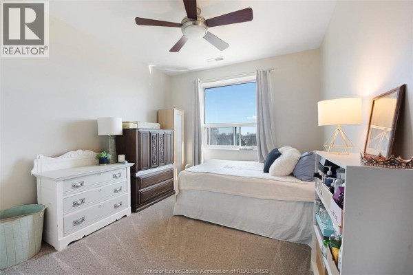 Bedroom with ceiling fan, bed, window view, dressers, and lamps - 1225 Riverside Unit# 409 Windsor