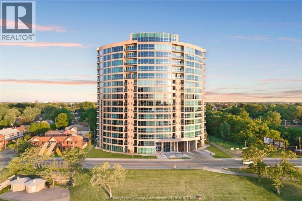 Modern glass high-rise building with balconies and arched entrance - 1225 Riverside Unit# 409 Windsor