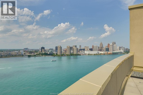 Balcony view of Detroit skyline across the river with a boat - 1225 Riverside Unit# 409 Windsor