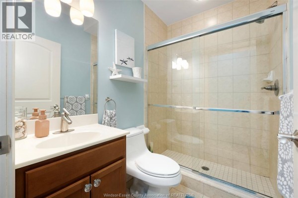 Kitchen with granite island, bar stools, wooden cabinets, and black appliances - 1225 Riverside Unit# 409, Windsor