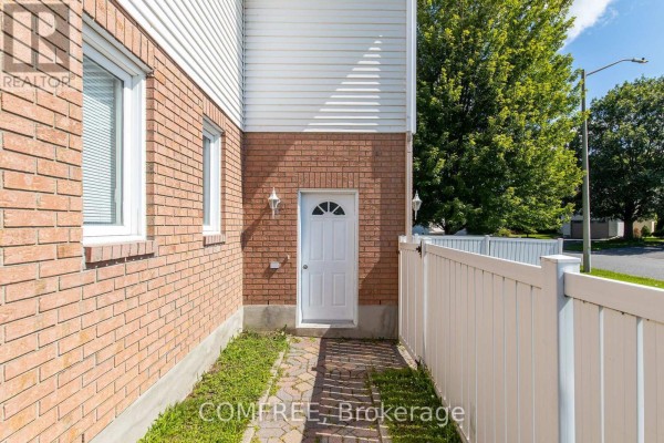 Modern white kitchen with stainless steel appliances, island, marble backsplash, and wood floors. - 1226 Matheson Road, Ottawa