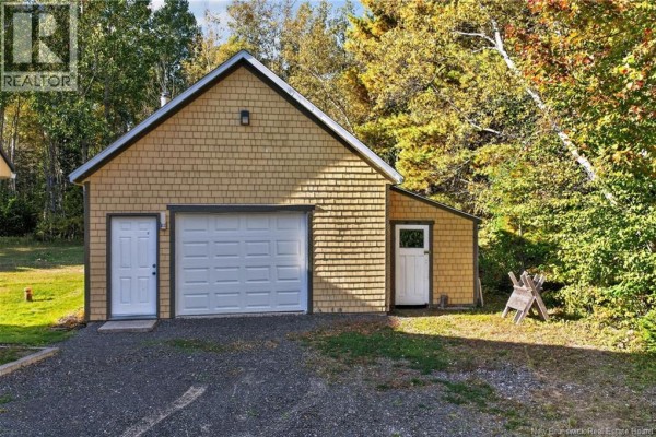 Yellow wood-shingled detached garage with a white overhead door and two side doors. - 1227 California Road, Galloway