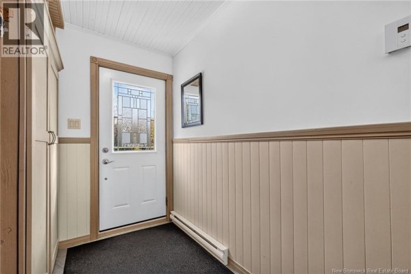 Interior view of a white front door with stained glass and beadboard paneling. - 1227 California Road, Galloway