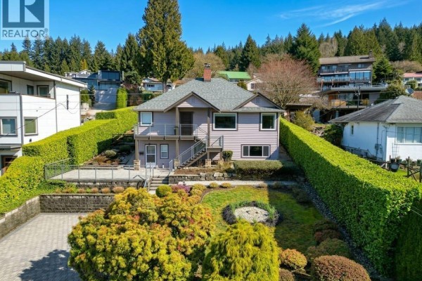 Cozy living area featuring a stone fireplace and comfortable seating. - 1227 Ioco Road, Port Moody