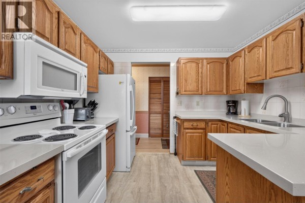 Sunroom with glass walls and ceiling, furnished with a chair and table. - 1229 Bernard Avenue Unit# 102, Kelowna