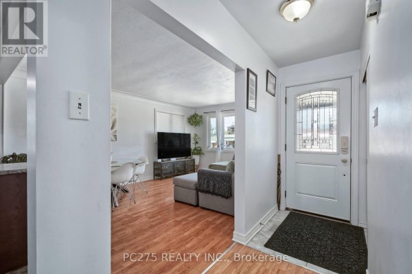 Interior view of the home's entrance foyer, with a view into the living room and dining area. - 1229 Exmouth Street, Sarnia