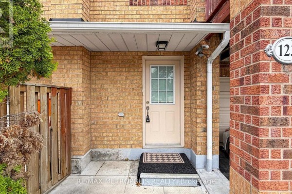 Close-up of a light beige front door with a glass pane, surrounded by brick. - 123 - 2 Hedge End Road, Toronto