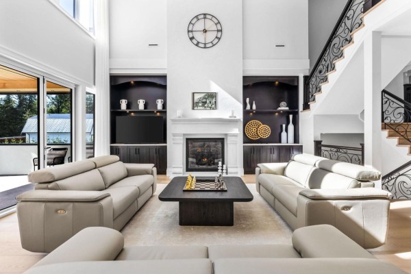Living room with vaulted ceiling, fireplace, built-in shelves, and a grand staircase. - 123 208 Street, Langley