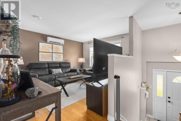 View from top of stairs to living area with charcoal couches and TV. - 123 Lancaster Drive, Dartmouth