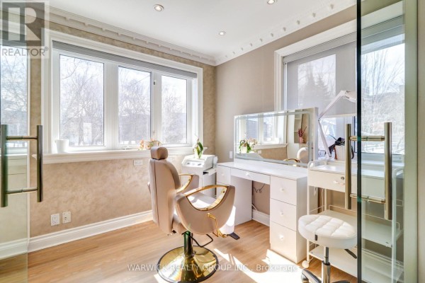 A room with a makeup chair, vanity, mirror, and large windows. - 123 Sheppard Avenue E, Toronto