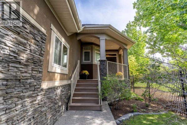 Front entrance with stone accents, a covered porch, and steps leading up. - 123 West Grove Rise Sw, Calgary