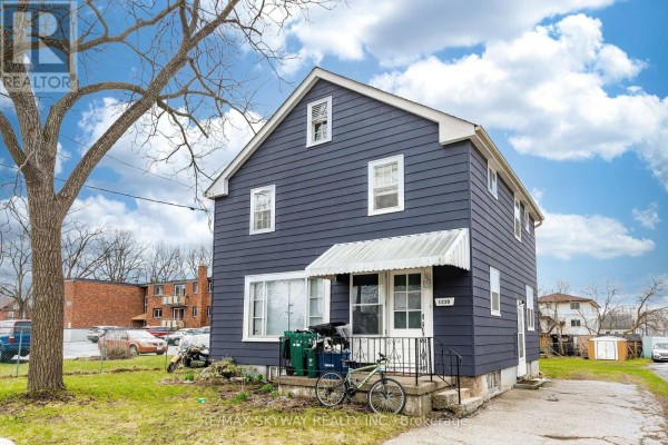 Side view of the blue house with white windows and a white awning over the front door. - 1230 Duke Street, Cambridge