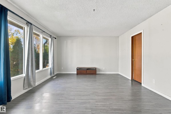 Interior view of a closet with a white wire shelf and light grey walls. - 12303 115 Av Nw, Edmonton