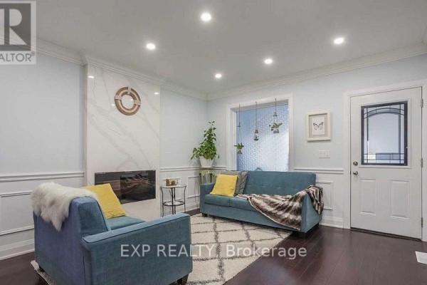 Living room with two blue sofas, a fireplace, and a door leading outside. - 1231 Bathurst Street, Toronto