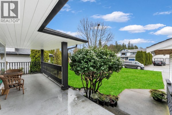 Angle view of house highlighting porch and landscaped yard with neighboring homes. - 12329 Bonson Road, Pitt Meadows