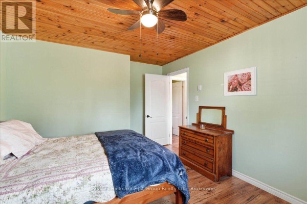 Bedroom with wood paneled ceiling and floral bedspread - 1233 Lazier Road Tyendinaga