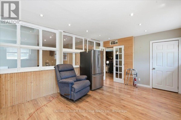 Recliner, refrigerator, and wood paneling - 1233 Lazier Road Tyendinaga