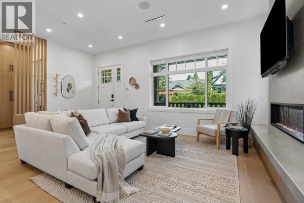 Entrance area with a white door, wood slat divider, and natural light from the window. - 1234 E 19th Avenue, Vancouver