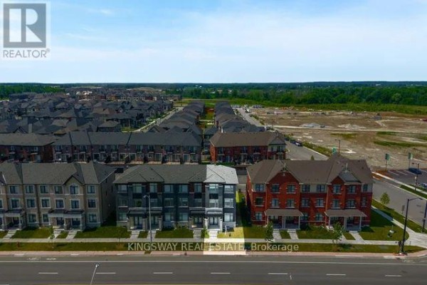 Aerial view of a street with rows of townhouses and surrounding development. - 12362 Mclaughlin Road, Caledon