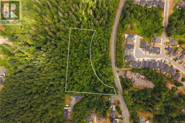 Aerial view of a tree-filled property with white boundary, adjacent to a street and homes. - 1237 4th Ave, Ladysmith