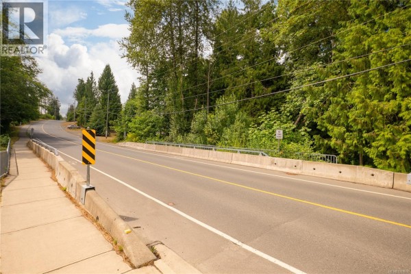 View from a sidewalk looking across a concrete bridge with traffic lanes and trees. - 1237 4th Ave, Ladysmith