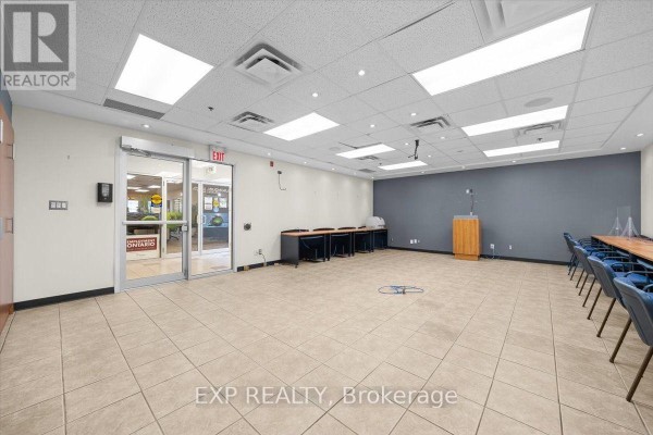 Interior view of a hallway with seating, glass-walled offices, and entrances. - 124 - 40 Sunset Boulevard, Perth