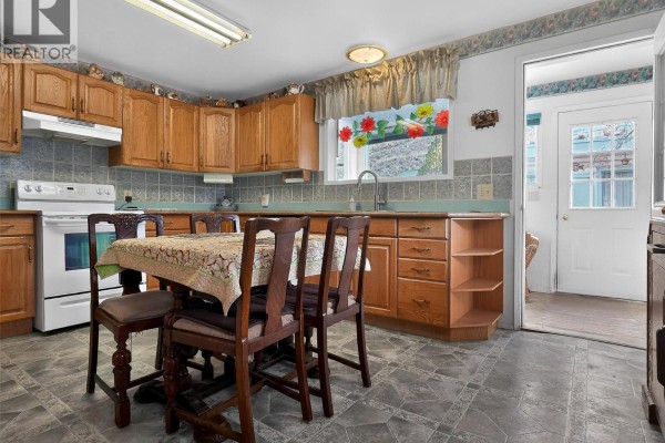 Another angle of the kitchen showing cabinetry, dining table, and access to the exterior - 124 97c Highway, Ashcroft