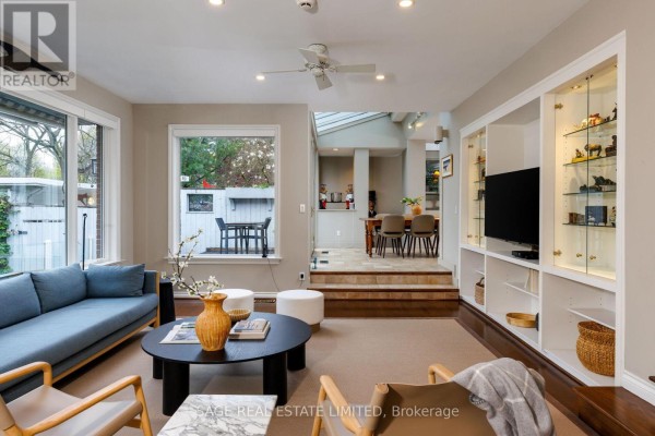 Living room with blue sofa, built-in cabinets, and skylight - 124 Blythwood Road Toronto