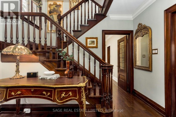 Foyer with a decorative wooden desk, ornate lamp, and a view of the staircase. - 124 Brentwood Road N, Toronto