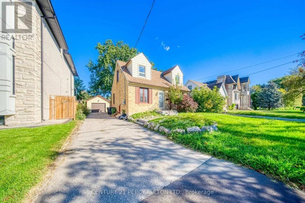 Front view of a yellow brick house with a pitched roof and dormer windows. - 124 Homewood Avenue, Toronto