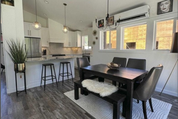 Open concept dining area with dark table, chairs, and white kitchen island. - 124 Ray Knight Dr, Ladysmith