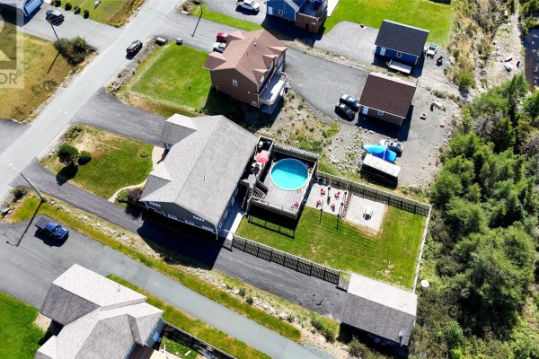 Aerial view of house with fenced backyard featuring a round above-ground pool and deck. - 124 Sheldon Drive, Bay Bulls