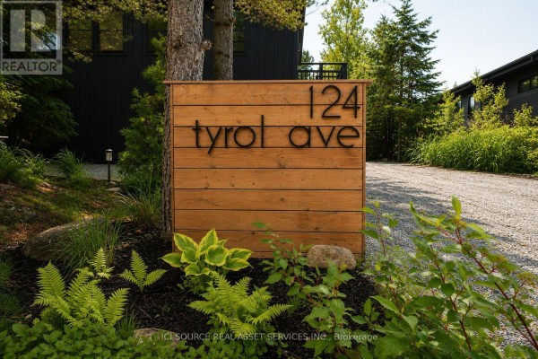Wooden sign with house number "124" and street name "Tyrol Ave" surrounded by plants. - 124 Tyrol Avenue, Blue Mountains
