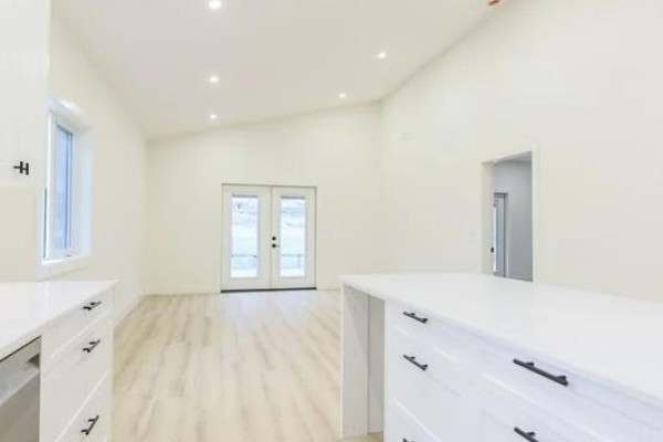 Side view of contemporary house featuring stone and wood elements with garage. - 1242 Copper Road, Oliver