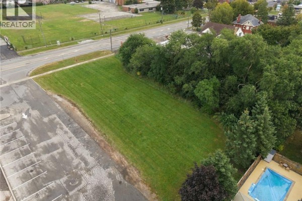Aerial view of the grassy lot with a swimming pool and trees in the background. - 1242 Highway 8, Hamilton