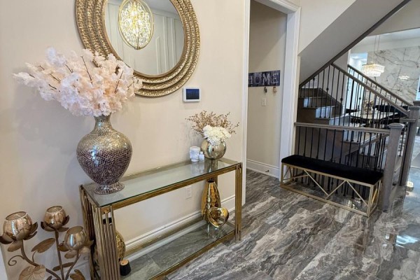 Entryway with a console table, mirror, vase, bench, and marble tile flooring. - 1246 Pondside Trail, Oakville