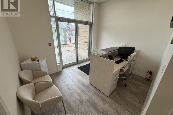 Reception desk and waiting area with two beige chairs by the entrance - 125 - 701 Sheppard Avenue W, Toronto