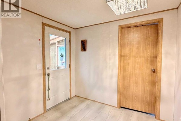 Interior entryway with a white door, wood-look floor, and a second door to the right. - 125 1 Avenue, Leslieville