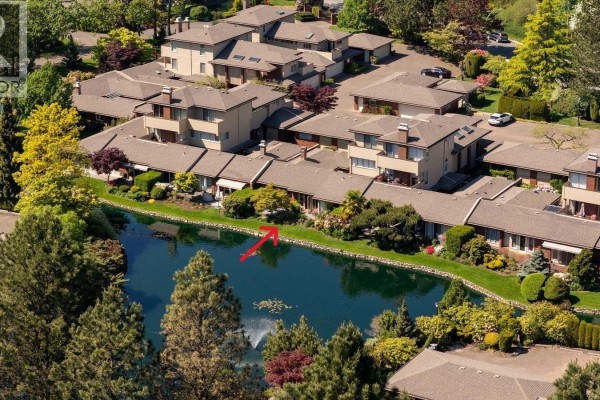 View of a serene pond with trees and a seating area. - 125 2345 Cedar Hill Cross Rd, Oak Bay