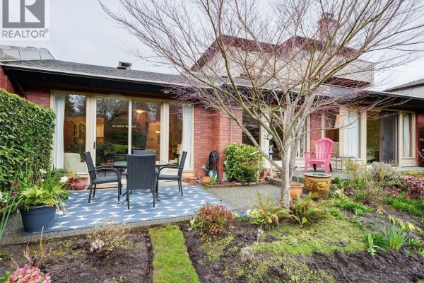 Lush garden with a pond featuring a fountain and vibrant greenery. - 125 2345 Cedar Hill Cross Rd, Oak Bay