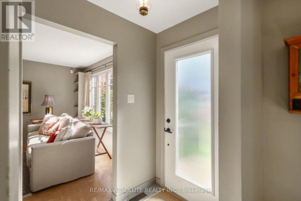 View of a home's entryway with a frosted glass door and an opening to the living area. - 125 Juniper Street E, Ottawa