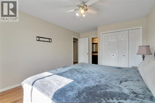 Bedroom with ceiling fan, double closet, and en suite bathroom view - 125 Queen Street South Tilbury