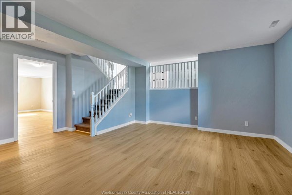 Hallway with white banister and wood-look flooring - 125 Queen Street South Tilbury