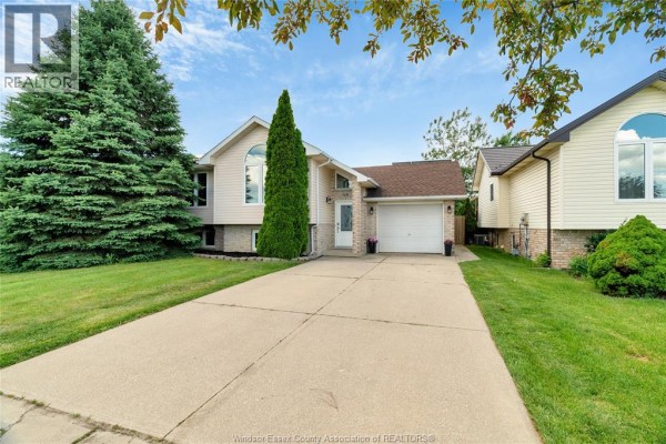 Exterior of a home with an attached garage and large evergreen tree - 125 Queen Street South Tilbury