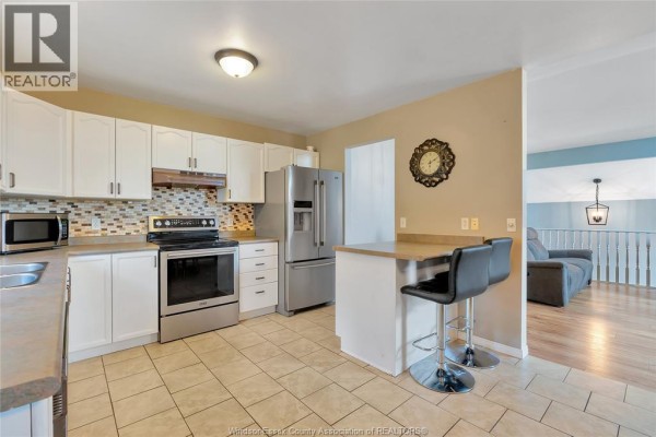 Kitchen with stainless steel appliances, breakfast bar, and tile floor - 125 Queen Street South Tilbury