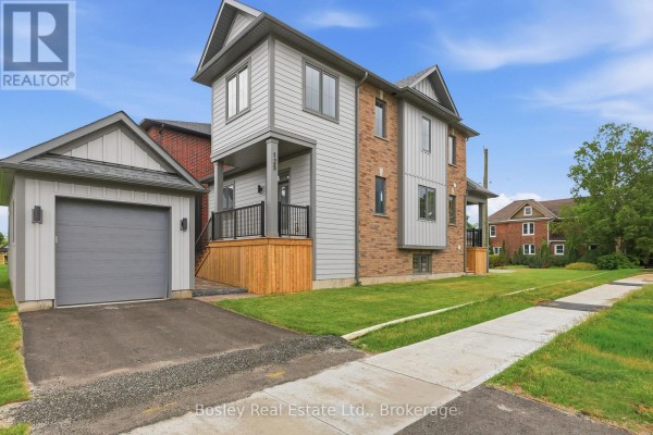 Exterior view of the house and attached garage with a paved driveway and sidewalk. - 125 Sixth Street, Collingwood