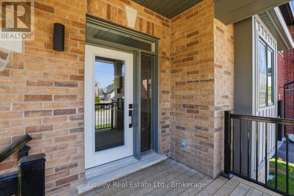Close-up of the front door with glass panels, surrounded by brick and wood siding. - 125 Sixth Street, Collingwood