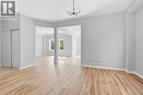 Interior view of a home's entryway with white double doors with frosted glass panels and a shoe rack. - 125 Tumblewood Place, Welland